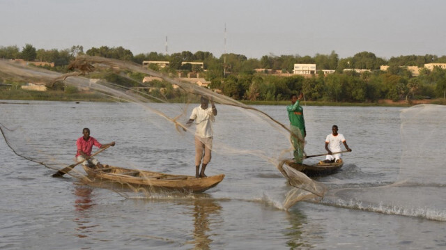Des pêcheurs de l'île de Néni-Goungou lancent leurs filets lors de la pêche sur le fleuve Niger à Niamey, le 27 février 2024.