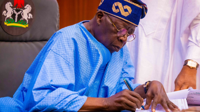 Le Président de la République fédérale du Nigeria, Bola Ahmed Tinubu, signe un document.