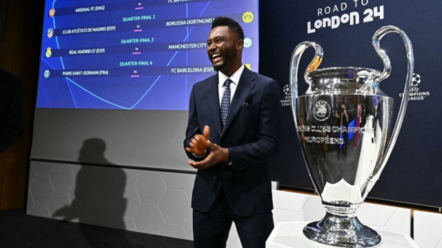 L'ancien footballeur nigérian John Obi Mikel pose à côté du trophée après avoir procédé au tirage au sort des quarts de finale de la Ligue des champions de l'UEFA 2023-2024, à la maison de l'UEFA, le 15 mars 2024.