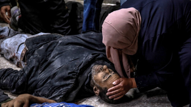 Une femme palestinienne identifie un membre de sa famille tué lors d'un bombardement israélien devant la morgue de l'hôpital Al-Shifa dans la ville de Gaza, le 15 mars 2024.