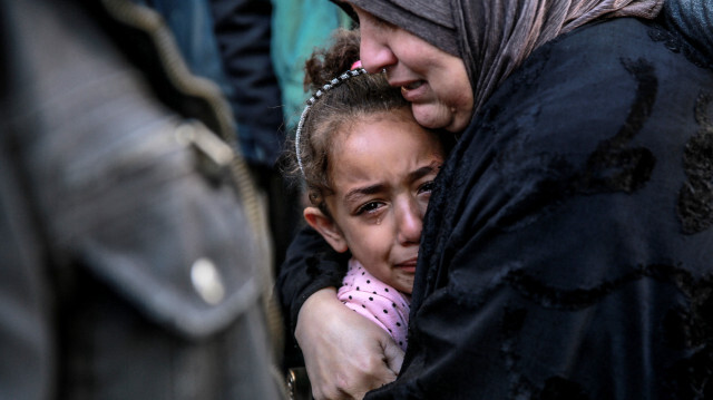 Une femme palestinienne tenant un enfant alors qu'elles pleurent leurs proches tués lors d'un bombardement israélien devant la morgue de l'hôpital Al-Shifa dans la ville de Gaza le 15 mars 2024, dans le cadre du conflit actuel entre Israël et le mouvement palestinien Hamas.