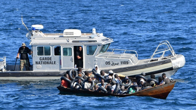 Des migrants tentant de fuir vers l'Europe sont entassés à bord d'une petite embarcation, alors que les garde-côtes tunisiens s'apprêtent à les transférer sur leur navire, en mer entre la Tunisie et l'Italie, le 10 août 2023.