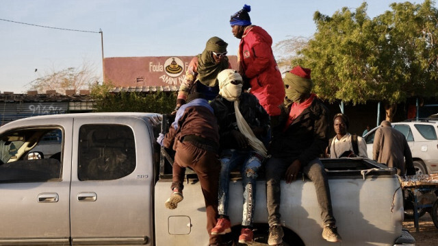 Des migrants sont assis à l'arrière d'un pick-up quelques minutes avant de se rendre à la frontière libyenne à Agadez, le 2 janvier 2024.