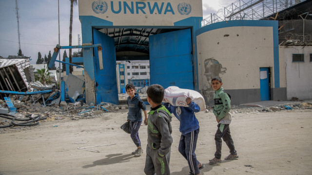 Des enfants portant des sacs de farine après la distribution de l'aide humanitaire dans la ville de Gaza le 17 mars 2024, au milieu des batailles entre Israël et le groupe militant Hamas.