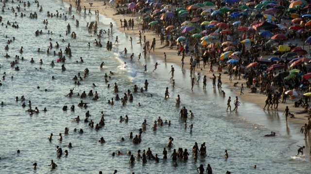 Brésiliens profitant de la plage de Recreio dos Bandeirantes en pleine vague de chaleur à Rio de Janeiro, Brésil, prise le 17 mars 2024.