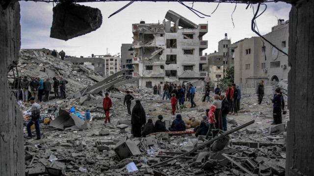 Des Palestiniens inspectant les décombres d'un immeuble détruit lors d'une frappe israélienne dans le quartier d'al-Rimal à Gaza City, le 16 mars 2024.