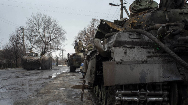 Les soldats ukrainiens circulent à bord de véhicules blindés de transport de troupes (APC) sur la ligne de front dans le village d'Orlovka.