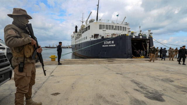 Les forces de sécurité montent la garde près du navire roulier "Star N", battant pavillon des Palaos, amarré avant son voyage vers Tunis au port maritime de Shuab, à Tripoli, la capitale de la Libye, qui a repris ses activités après plusieurs années de fermeture, le 12 février 2023.