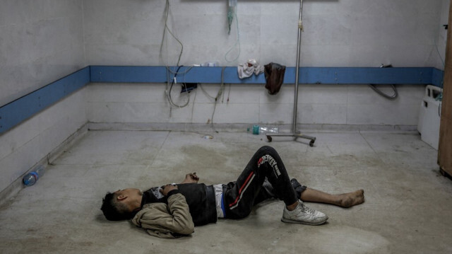 Un enfant Palestinien blessé par un bombardement israélien est allongé sur le sol alors qu'il attend des soins médicaux à l'hôpital Al-Shifa dans la ville de Gaza, le 15 mars 2024.