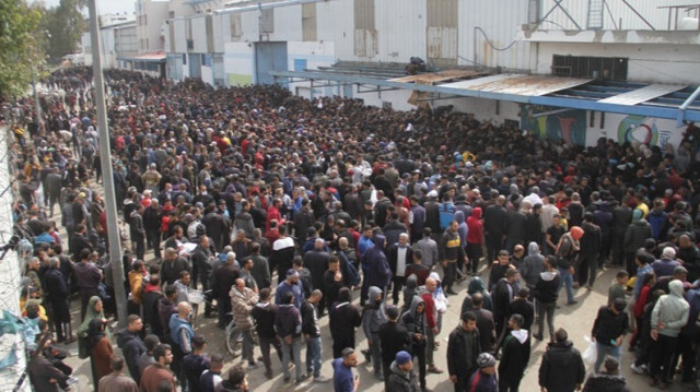 Des Palestiniens attendent devant le centre de distribution de l'UNRWA pour recevoir une quantité limitée de farine alors que les attaques israéliennes se poursuivent sur la ville de Gaza, le 18 mars 2024.