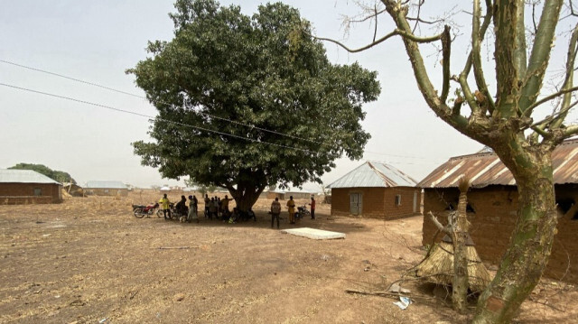 Des habitants du village de Tantatu Ward se tiennent devant leur maison dans le district de Kajuru Station, le 19 mars 2024.