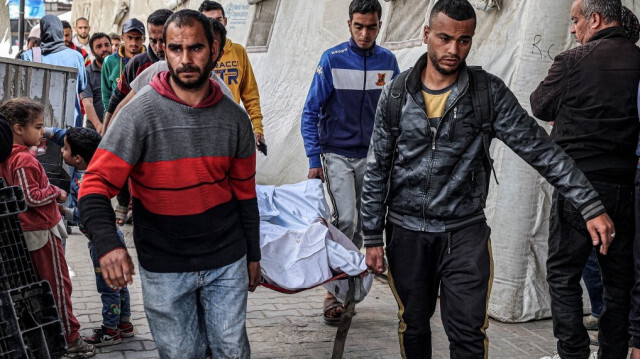 Des hommes portent les corps des victimes qui ont été tuées dans une frappe aérienne israélienne sur un bâtiment à l'hôpital Al-Najjar à Rafah dans le sud de la bande de Gaza le 20 mars 2024.