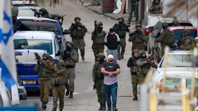 Des troupes israéliennes arrêtent des hommes palestiniens lors d'un raid en Palestine occupée.