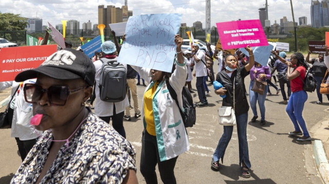 Des travailleurs de la santé qui ont travaillé pendant quatre ans sous contrat dans des établissements de santé publique manifestent avec des pancartes et des sifflets à l'entrée du ministère de la santé à Nairobi le 20 mars 2024 pour réclamer l'emploi permanent que le gouvernement kenyan leur avait assuré après trois ans de service. 