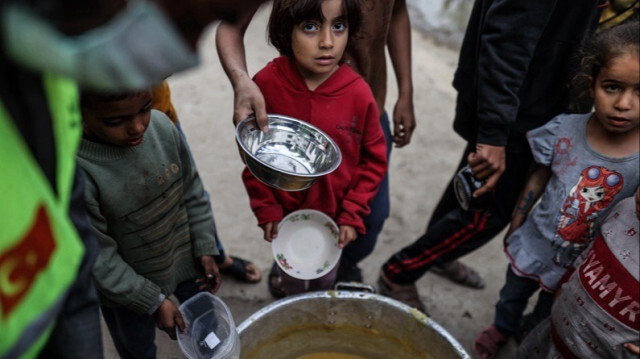 Des enfants palestiniens font la queue pour recevoir de la nourriture distribuée par des organisations caritatives à Gaza, le 21 mars 2024.