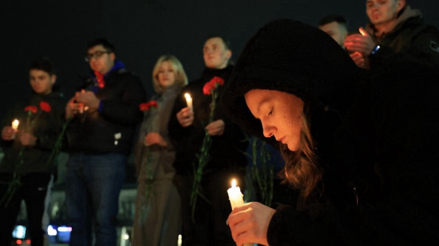 Des personnes déposent des fleurs et allument des bougies à la mémoire des victimes de l'attentat de Moscou dans le centre de Simferopol, en Crimée, le 22 mars 2024. 