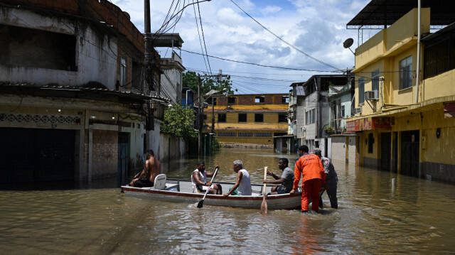 Des habitants naviguant sur un bateau dans une zone inondée de la communauté Lote XV à Belford Roxo, État de Rio de Janeiro, Brésil, le 15 janvier 2024. 
