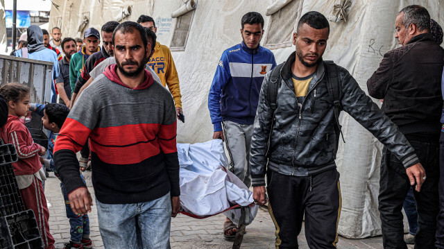 Des hommes portant les corps des victimes tuées lors d'une frappe aérienne israélienne sur un bâtiment de l'hôpital Al-Najjar à Rafah, dans le sud de la bande de Gaza, le 20 mars 2024, dans le cadre du conflit en cours dans le territoire palestinien entre Israël et le groupe militant Hamas.
