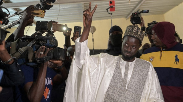 Le candidat à la présidence Bassirou Diomaye Faye fait un geste après avoir déposé son bulletin de vote au bureau de vote de l'École Ndiandiaye à Ndiaganiao, le 24 mars 2024, lors des élections présidentielles au Sénégal.