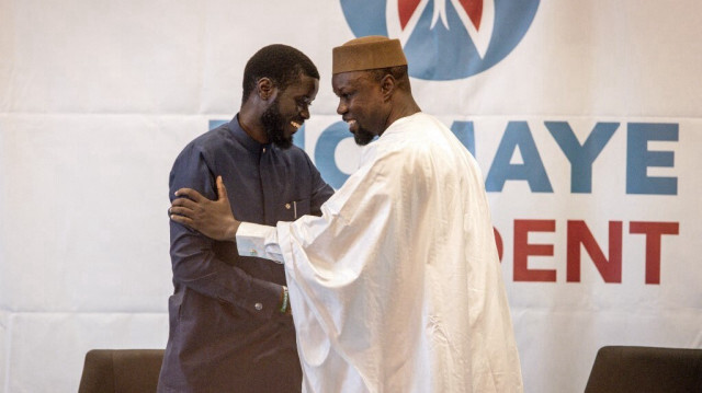 Le chef de l'opposition Ousmane Sonko (à droite), qui a été libéré de prison la veille, salue le candidat à la présidence Bassirou Diomaye Faye (à gauche) lors d'une conférence de presse à Dakar le 15 mars 2024. 