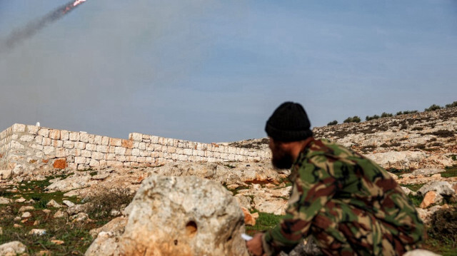 Un combattant syrien affilié au groupe Hayat Tahrir al-Sham (HTS) actionne la télécommande d'un lance-roquettes monté sur un pick-up qui tire sur les positions des forces gouvernementales syriennes dans le nord-ouest de la province d'Alep, le 1er janvier 2024.