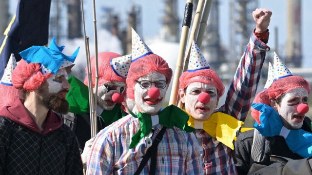 Des militants du mouvement environnemental mondial Extinction Rebellion (XR), déguisés en clowns, devant la raffinerie TotalEnergies de Donges, lors d'une manifestation organisée pour marquer le 100e anniversaire de l'entreprise, le 23 mars 2024.