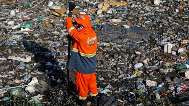 Des travailleurs municipaux nettoyant les déchets du ruisseau Cachoeirinha à Manaus, Brésil, le 25 juillet 2022.