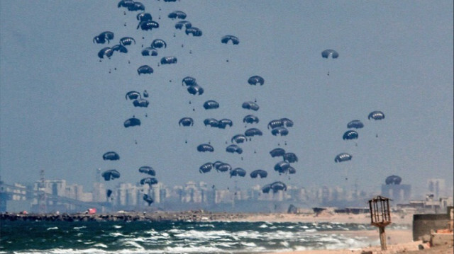 Des colis d'aide humanitaire atterrissent à l'aide de parachutes après avoir été largués d'un avion alors que les attaques israéliennes se poursuivent dans la Bande de Gaza, le 25 mars 2024.