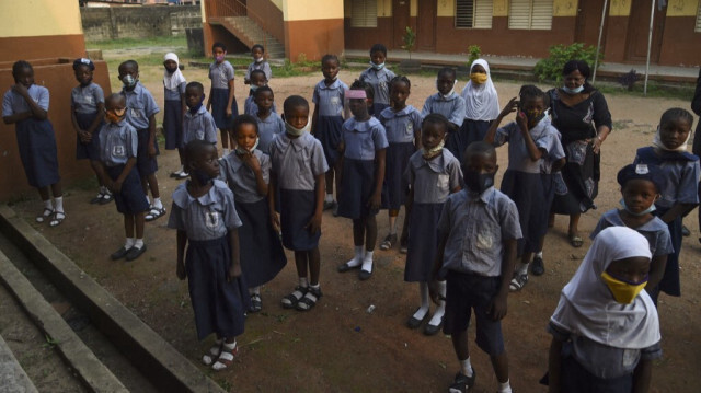 Des élèves se tiennent debout lors d'une assemblée après la reprise des cours à l'école maternelle et primaire Obele-Odan à Surulere, à Lagos, au Nigeria, le 18 janvier 2021. 