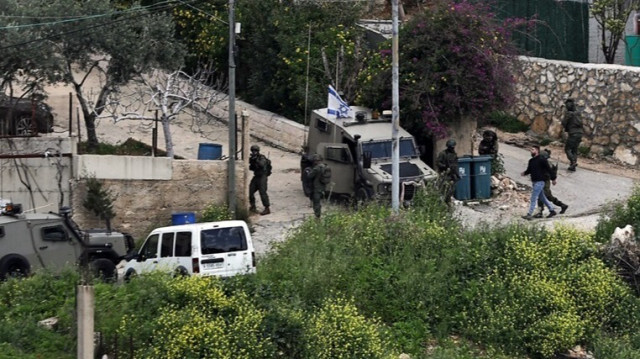 Les forces israéliennes arrêtent un homme lors d'une opération en Palestine occupée.