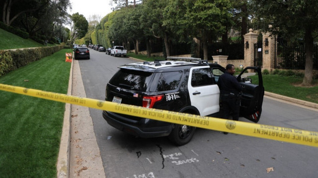 Des voitures de police sont visibles derrière du ruban de précaution devant la maison du producteur et musicien américain Sean "Diddy" Combs à Los Angeles le 25 mars 2024.