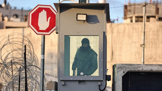 Un soldat israélien monte la garde au poste de contrôle à Qalandia, en Palestine occupée, le 22 mars 2024.
