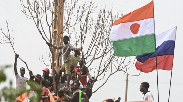 Les drapeaux nationaux du Niger et de la Russie sont visibles alors que des partisans du Conseil national de sauvegarde de la patrie (CNSP) du Niger manifestent devant la base aérienne nigéro-française de Niamey, le 2 septembre 2023, pour demander le départ de l'armée française du Niger.