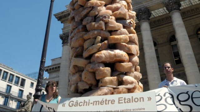 Statue réalisée avec des tranches de pain, enduites de résine, pour sensibiliser au gaspillage, sur la place de la bourse à Paris.