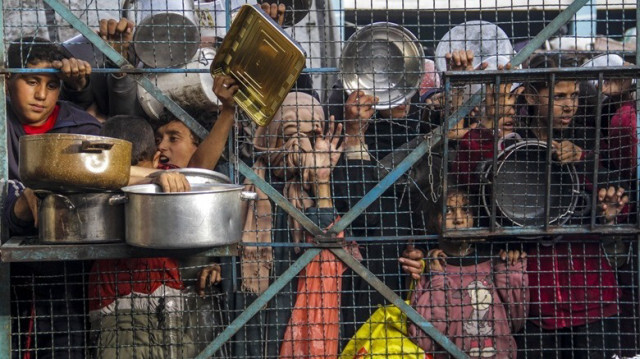Des Palestiniens attendent de recevoir de la nourriture distribuée par des organisations caritatives dans le cadre du blocus israélien à Gaza, le 27 mars 2024.