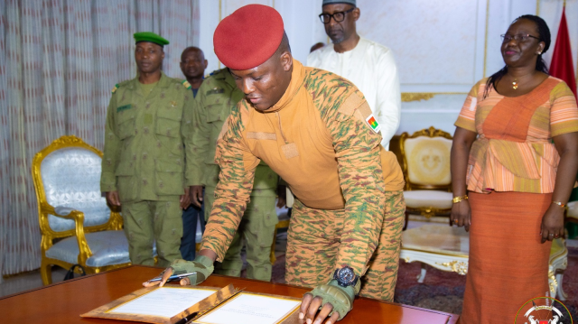 Le chef de L'État du Burkina Faso, le Capitaine Ibrahim Traoré, signant un document.