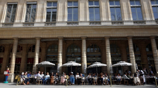 Des personnes prennent un verre sur la terrasse du restaurant et café Nemours sur la place Colette, au centre de Paris, le 20 mars 2024.