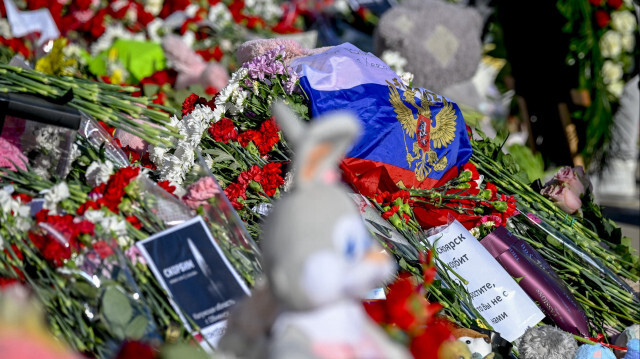 Люди возлагают цветы перед "Крокус Сити Холлом" в память о жертвах теракта в концертном зале "Крокус" в Москве, Россия, 27 марта 2024 года. Число погибших и раненых в результате теракта в концертном зале в Подмосковье на прошлой неделе возросло до 140 и 360 человек соответственно, сообщили местные власти. Следственный комитет сообщил, что задержал 11 человек, включая четырех исполнителей, которые направлялись в Украину, в приграничном Брянске.