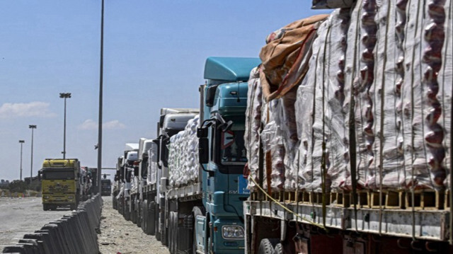 Des camions transportant de l'aide humanitaire à destination de la Bande de Gaza font la queue devant le poste-frontière de Rafah du côté égyptien.