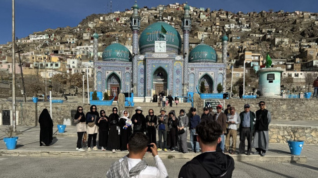 Des touristes thaïlandais posent pour une photo de groupe lors de leur visite au complexe de Kart-e-Sakhi à Kaboul, le 25 mars 2024.