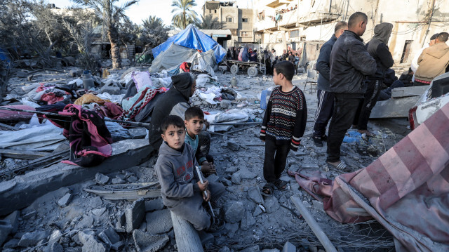 Des enfants assis au milieu d'abris de fortune détruits près des décombres d'une mosquée détruite par des frappes israéliennes à Deir El-Balah, dans le centre de la bande de Gaza, le 2 mars 2024.