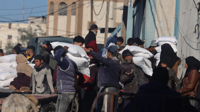 Des personnes recevant des sacs de farine distribués par une organisation humanitaire des Nations Unies à Rafah, dans le sud de la bande de Gaza, le 3 février 2024.