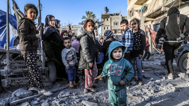 Des enfants se tenant au milieu des décombres d'une mosquée et d'abris de fortune détruits par des frappes israéliennes à Deir El-Balah, dans le centre de la bande de Gaza, le 2 mars 2024.