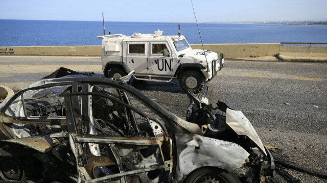 Une patrouille de la FINUL (Force intérimaire des Nations Unies au Liban) passe devant l'épave d'une voiture qui a été visée par une frappe israélienne le 2 mars 2024, près de la ville de Naqoura, dans le sud du Liban.