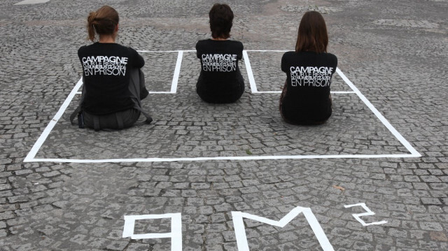 Trois membres du collectif "Trop c'est trop" assises dans un carré de 9m2 dessiné sur le sol et reconstituant en taille réelle une cellule de prison, le 02 octobre 2007 sur la place de la Concorde à Paris, pour dénoncer la surpopulation carcérale et demander l'application d'un numerus clausus en prison. 