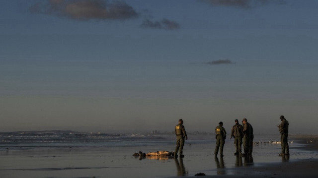 Des agents de la patrouille frontalière américaine regardent le corps d'un migrant décédé, au Mexique, le 9 novembre 2022.