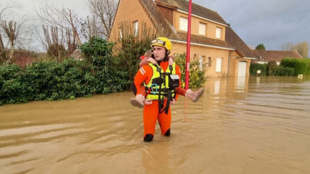 Cette photo prise le 3 janvier 2024 près de Saint-Omer, dans le nord de la France, et diffusée le 9 janvier 2024 par la Sécurité civile, l'agence de protection civile du gouvernement français, montre un sauveteur portant une fillette alors qu'il aide à évacuer les résidents, après que la région du Pas-de-Calais, près de la frontière belge, a connu des inondations dévastatrices.