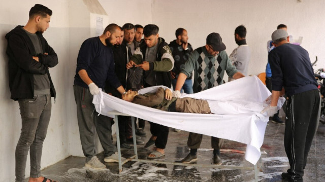 Des PalestinieNs préparent le corps d'un homme pour son enterrement à l'hôpital baptiste, également connu sous le nom d'hôpital arabe Al-Ahli, dans la ville de Gaza le 31 mars 2024.