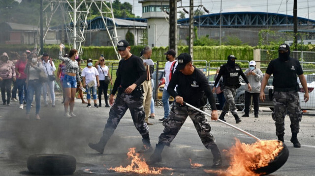 Des policiers dégagent la route lors d'une manifestation de parents de détenus aux abords du complexe pénitentiaire Regional 8 à Guayaquil, Équateur, le 28 mars 2024.