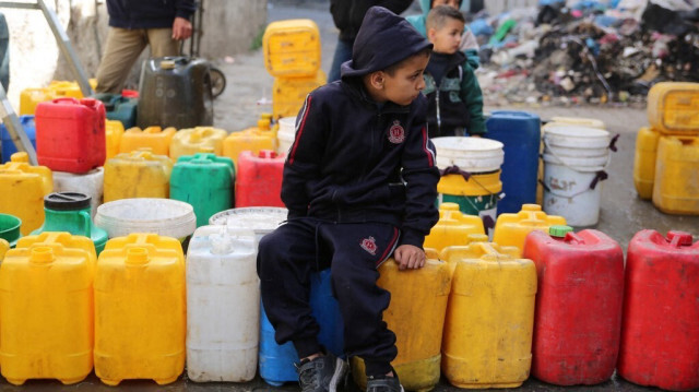 Des enfants palestiniens collectent de l'eau dans le quartier de Zaytoun, dans la ville de Gaza, le 31 mars 2024.